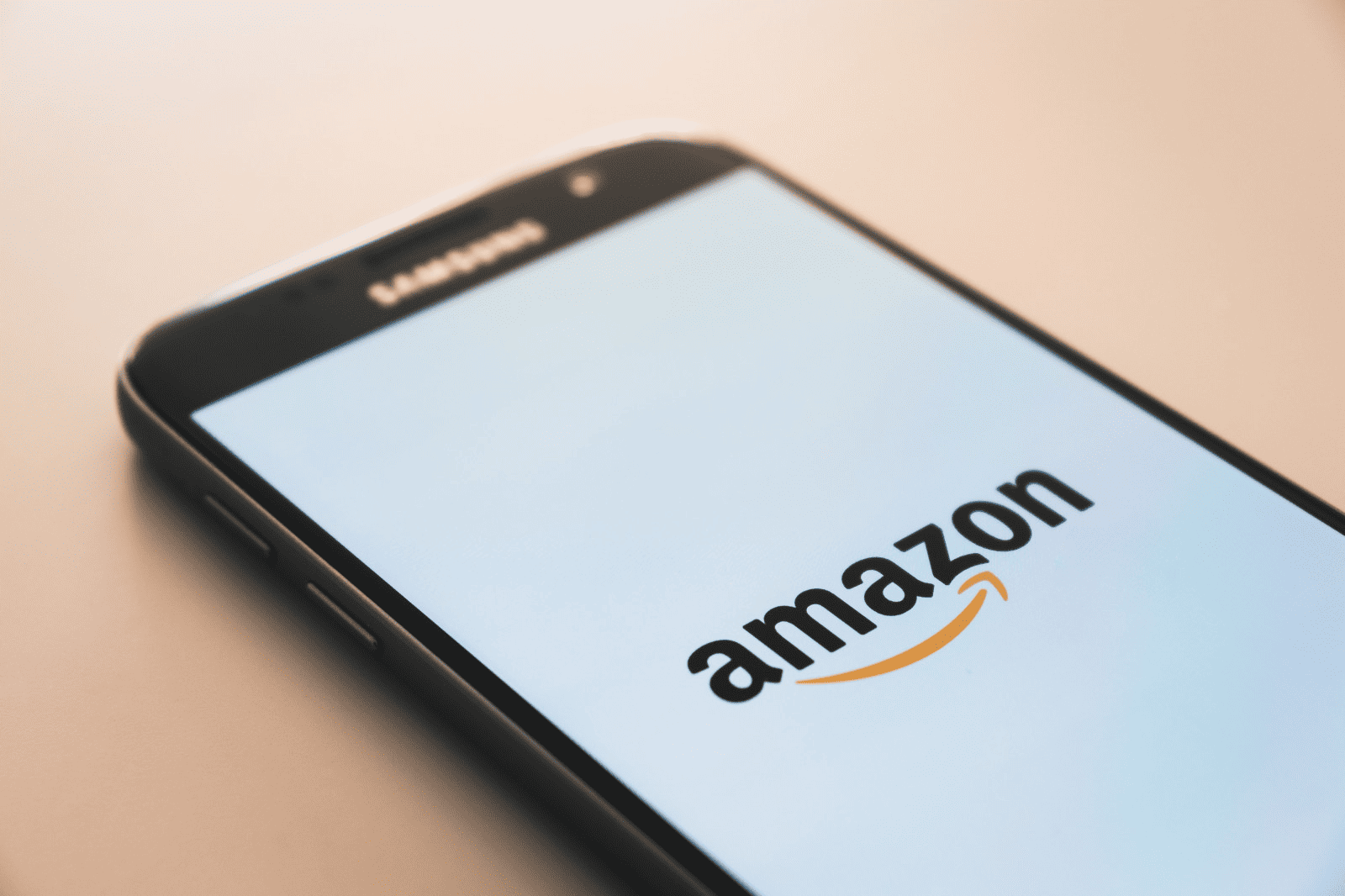 Amazon smartphone with app logo on screen, digital commerce, online shopping, mobile app interface, technology and retail trend.