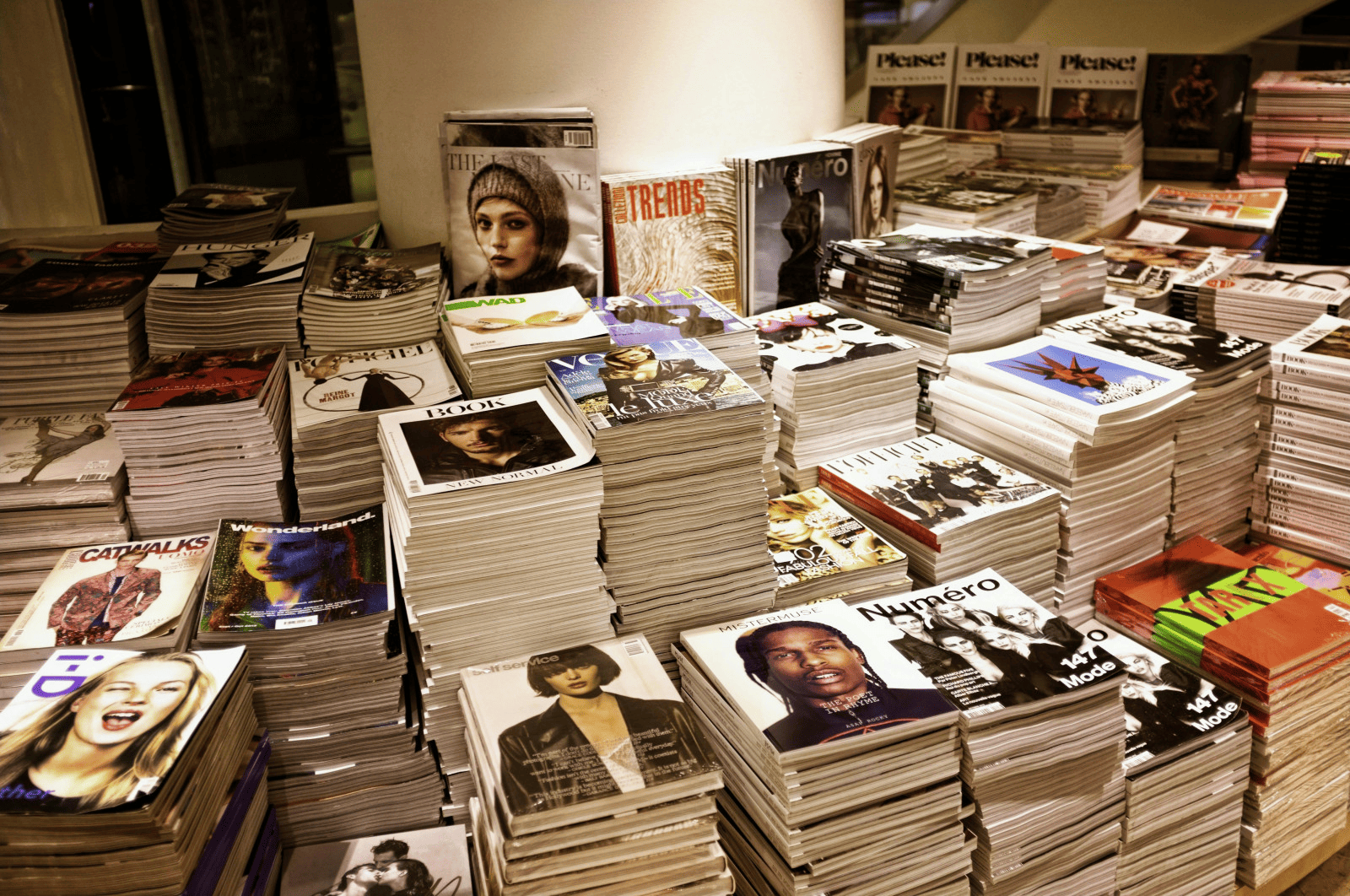 Magazine stacks at a bookstore or magazine stand showcasing fashion, entertainment, and lifestyle publications for magazine industry insights and trends.