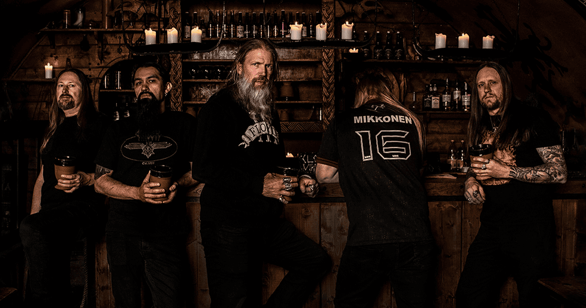 Dark-themed image of five long-haired musicians with tattoos, holding drinks, in a rustic bar setting with candles and wooden shelves, promoting music culture and live band ambiance.