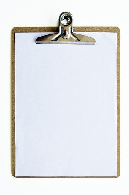 Clipboard with blank white paper for notes or music, on a plain background, ideal for music industry updates or artist branding content.