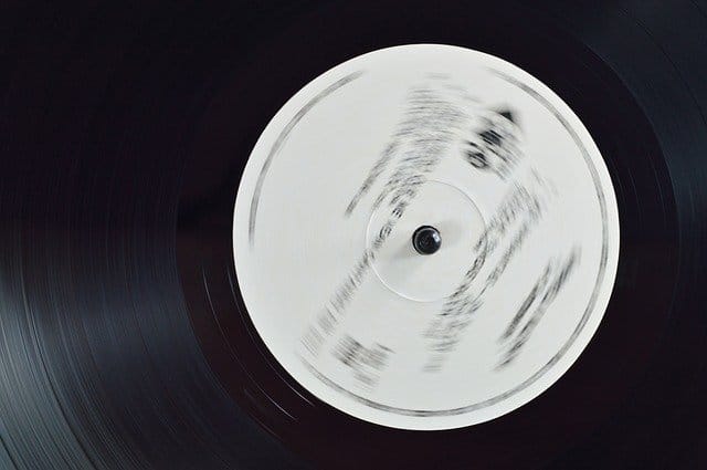 Vinyl record spinning on turntable, close-up of music industry technology and DJ equipment.