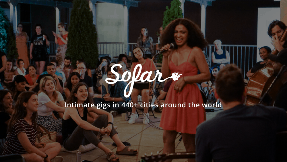 Performer singing with guitar at intimate social gathering, showcasing live music experience.