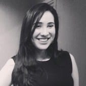 Alt text: Young woman with long dark hair smiling in black and white portrait, showcasing confidence and friendliness suitable for music and entertainment industry visuals.