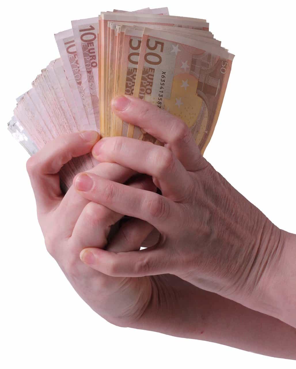 Stacks of 50 euro banknotes being held in a person's hand, illustrating cash, money, and currency.