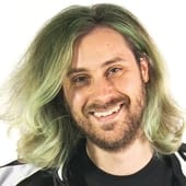 Creative music industry professional smiling with green-dyed hair, representing Hypebot's focus on music tech, innovation, and industry news.