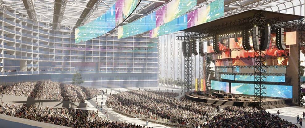 Hypebot at a large music concert or festival with a massive stage, vibrant screens, and a huge crowd of music fans enjoying an outdoor live performance.