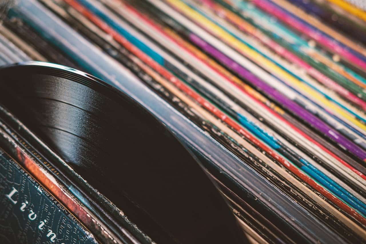 Vintage vinyl records stacked with colorful album covers, representing music, audio collection, and musical nostalgia for music enthusiasts and collectors.