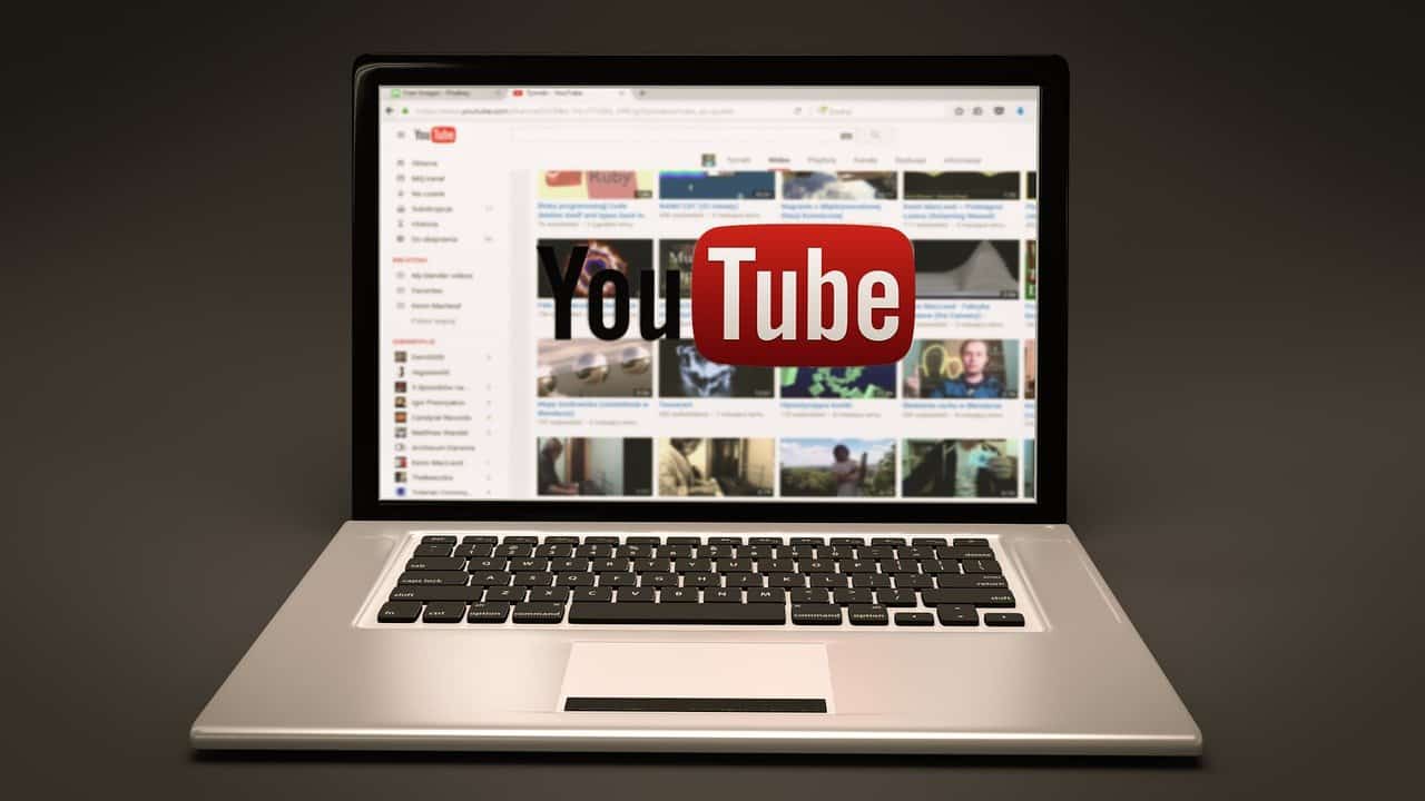 Youtube interface on laptop screen showing video thumbnails and channels.