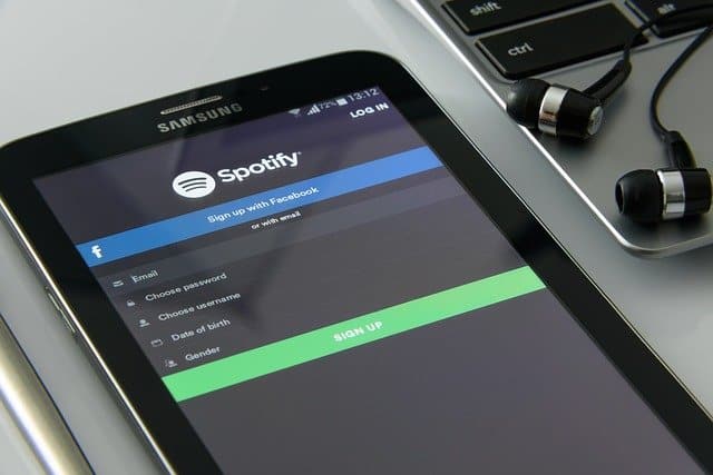 Spotify login screen on a smartphone with earphones nearby, representing music streaming and digital entertainment.