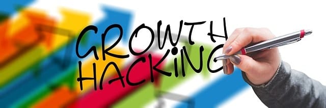 Innovative growth hacking strategy illustration with colorful background and hand writing "Growth Hacking" on whiteboard.