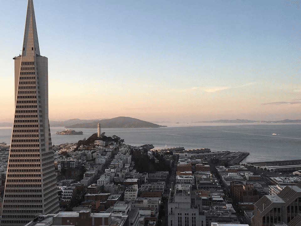 San Francisco cityscape with the Salesforce Tower and Bay Bridge, capturing iconic skyline and waterfront views at sunset, ideal for urban development and real estate content.