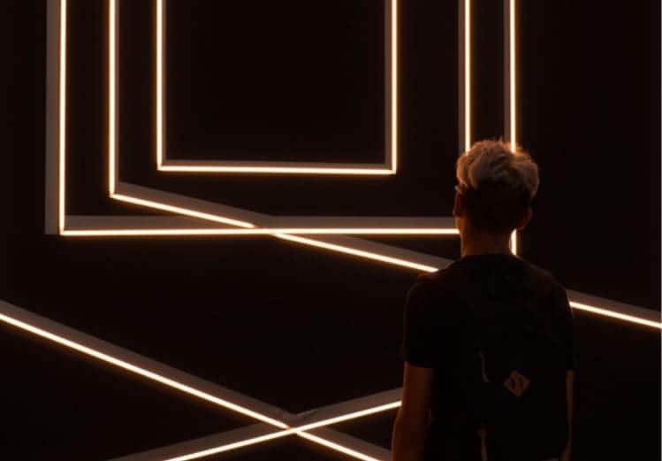 Futuristic dark room illuminated with geometric neon LED light frames, modern art installation, innovative design, creative space, immersive experience, technology-inspired environment, ideal for contemporary art and tech events.