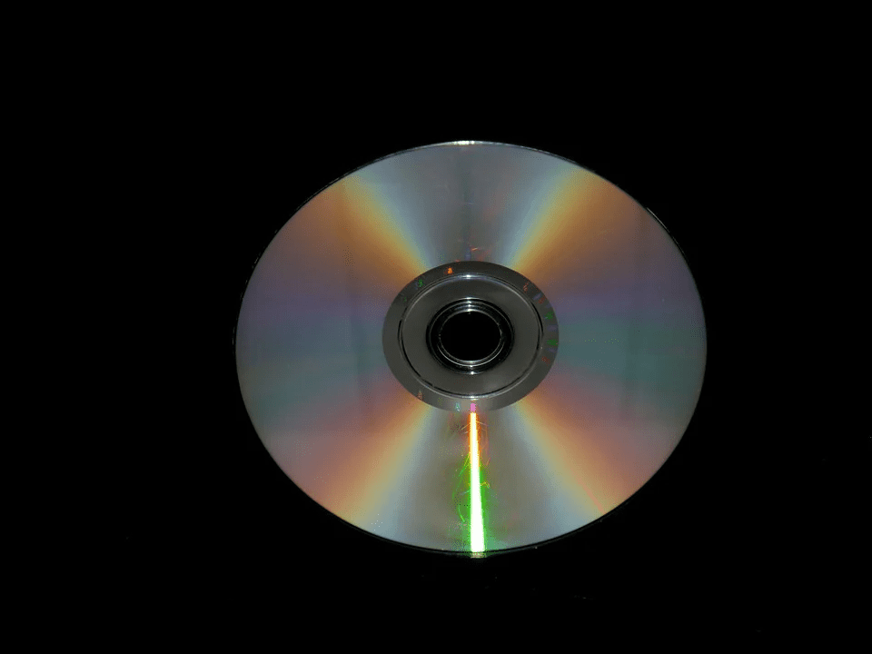 High-quality audio CD with reflective surface, set against black background, showcasing digital music technology and multimedia entertainment concept.
