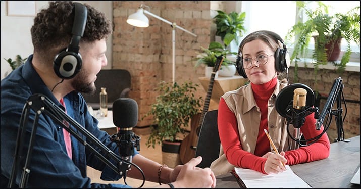 Podcast recording studio with two hosts using professional microphones and headphones for broadcasting.