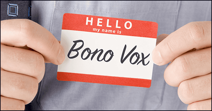 Bono Vox name tag held by person, symbolizing identity or artist recognition, on a gray shirt background.