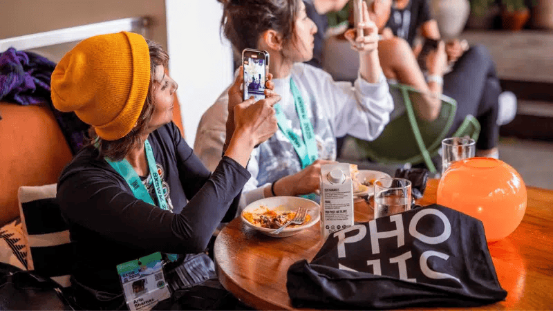 Kids taking photos at a social event, capturing moments with smartphones at a gathering, trendy outdoor dining experience with friends, casual social scene, vibrant atmosphere, lifestyle photography for social media content.