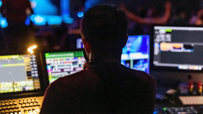 Hypebot, music industry technology, live music production, multimedia editing, digital music creation, professional DJ setup at night, music entertainment, audio-visual equipment, music event in a nightclub, electronic music setup, industry news for artists and creators.